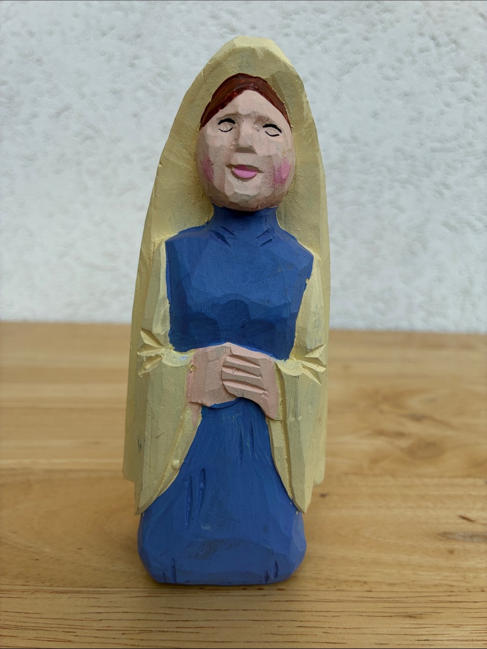 Carved wooden nun with blue and yellow clothing  handmade